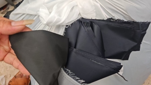长期出售做雨衣下来的涤纶复合布,涤纶复合pvc,雨衣边角料,现货40吨左右